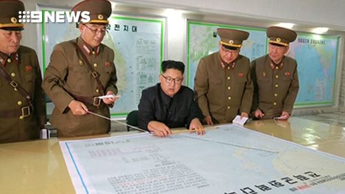 North Korean leader Kim Jong-un is seen reviewing a plan for an attack on Guam.