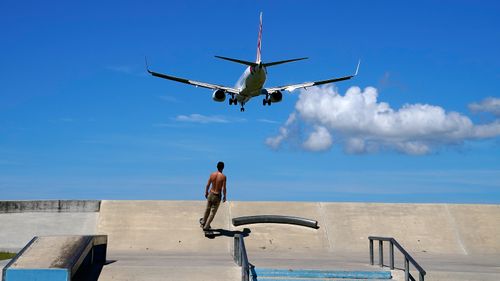 A skateboarder looks on as a Virgin commercial aircraft from Sydney lands at the Gold Coast Airport in March, 2020.