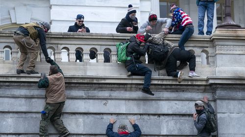 Rioters loyal to President Donald Trump climb the west wall of the the U.S. Capitol, Jan. 6, 2021, in Washington. 