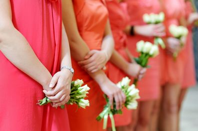 Row of bridesmaids with bouquets at wedding ceremony