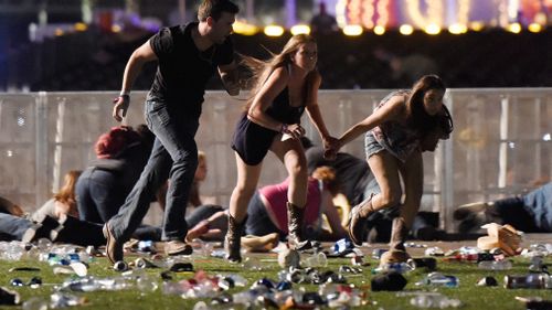 Concert-goers run from the spray of bullets. (Getty)