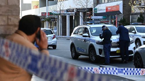 A member of the public looks out over a police crime scene on Spring Street in Bondi Junction.
