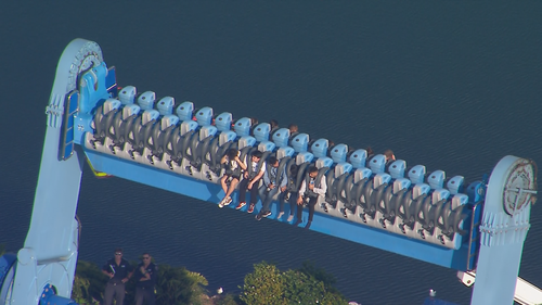 More than a dozen people are trapped on ride at Sea World on the Gold Coast, with staff at the theme park currently working to free them.