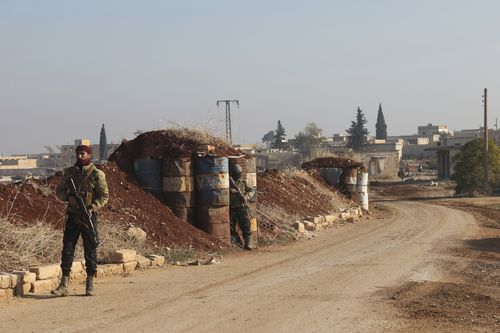 Syrian opposition fighters stand guard in Kafr Halab in the Aleppo countryside in Syria.