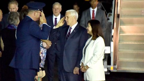 An official salutes US Vice President Mike Pence and his wife Karen on the tarmac in Cairns, Queensland.