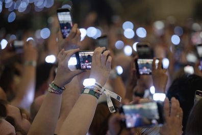 Spectators film with their smartphones during singer Taylor Swift's concert in the Veltins Arena in Gelsenkirchen, Germany, Thursday, July 18, 2024. 