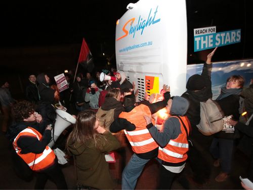 Protesters came close enough to the bus to hit it. (AAP)