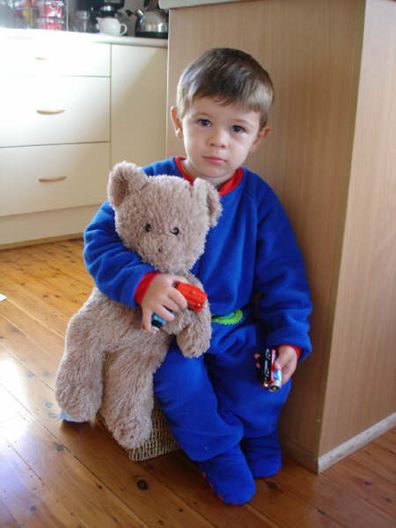 Isaac as a toddler holding a teddy bear