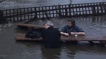 Two UK men decide to grab a pint as beer garden floods around them