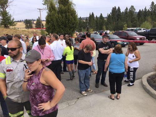 Parents gather in the parking lot behind Freeman High School to wait for their kids after the shooting. (AP)