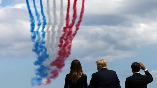 US First Lady Melania Trump, US President Donald Trump and French President Emmanuel Macron watch as French elite acrobatic flying team "Patrouille de France" (PAF) fly over after a French-US ceremony.