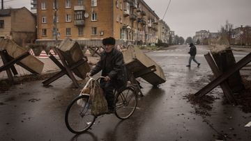A resident rides his bike through street barricades on December 13, 2022 in Bakhmut, Ukraine. 
