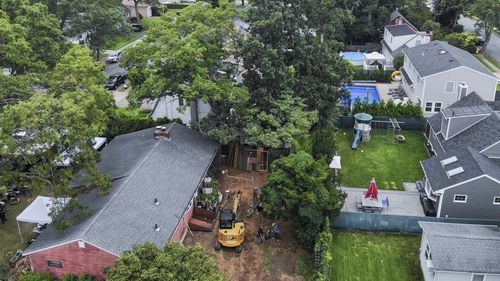 Authorities continue to work at the home of suspect Rex Heuermann, bottom left, in Massapequa Park, N.Y., Monday, July 24, 2023. Heuermann has been charged with killing at least three women in the long-unsolved slayings known as the Gilgo Beach killings. 