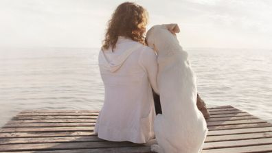 Dog and owner hugging.