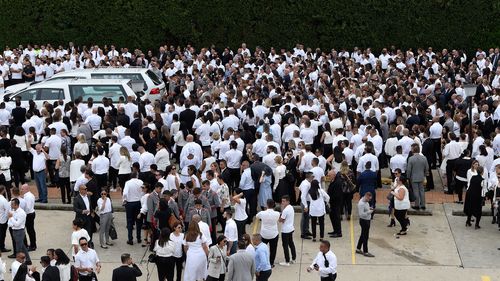 Mourners are seen behind the hearses after the funeral for Anthony Abdallah, 13, Angelina Abdallah, 12, and Sienna Abdallah, 8, at Our Lady of Lebanon Co-Cathedral in Sydney.