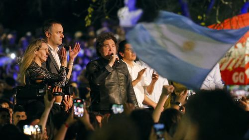 O presidente da Argentina, Javier Milei (R), fala ao lado do candidato legislativo Manuel Adorni (C) e da secretária-geral da Presidência da Argentina, Karina Milei, durante um comício político ao ar livre no Parque Sarmiento, em Córdoba, Argentina, em 19 de setembro.
