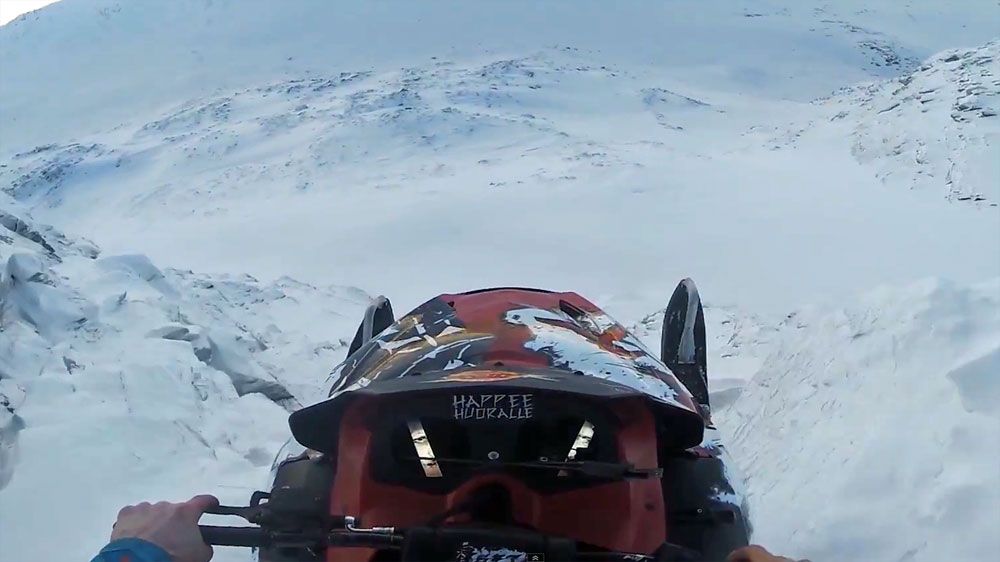 Stuntman soars off cliff on snowmobile