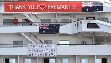 The MV Artania is seen with &quot;Thank You Fremantle&quot; banners and Australian flags positioned on the side of the vessel while berthed at the Fremantle Passenger Terminal