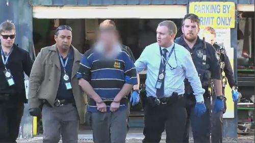 A man is handcuffed and flanked by police. Picture: Queensland Police Service