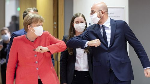 German Chancellor Angela Merkel (L) elbow bumps the President of the European Council Charles Michel (R) during an EU summit on July 17, 2020 in Brussels, Belgium. European Council President Charles Michel has called an extraordinary summit on Friday July 17 and Saturday July 18 to discuss the EU's post-coronavirus recovery plan and the 2021-2027 budget.