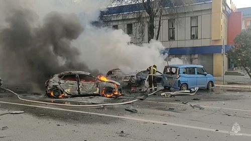 Firefighters extinguish burning cars after shelling in Belgorod, Russia