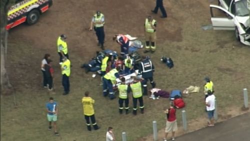 Paramedics treat members of the family who were injured in the crash. (9NEWS)