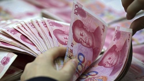 A clerk counts Chinese currency notes