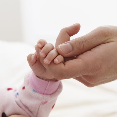 Father holding baby girl hand