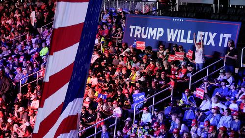 Donald Trump supporters and a sign saying "Trump will fix it".