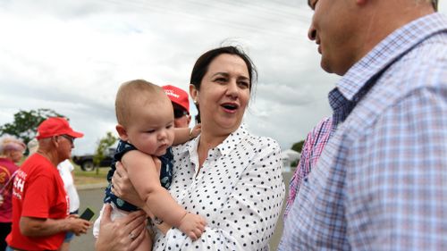 Queensland Premier Annastacia Palaszczuk holds a supporter's baby during a visit to a school in Gladstone. (Image: AAP)