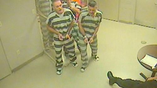 The prisoners marched out of the locked room, still in shackles. (WFAA)