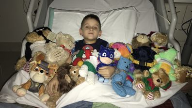 Chase in hospital with a collection of his favourite toys.