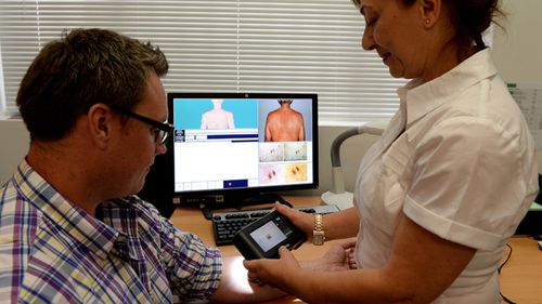 A patient is checked for possible skin cancers. (AAP)