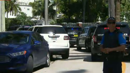 A Miami police officer stands on the street outside the mansion. (Local 10 News)