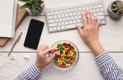  Work space with laptop, candies and woman hands on white background