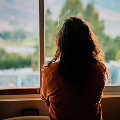 Woman alone looking out a window