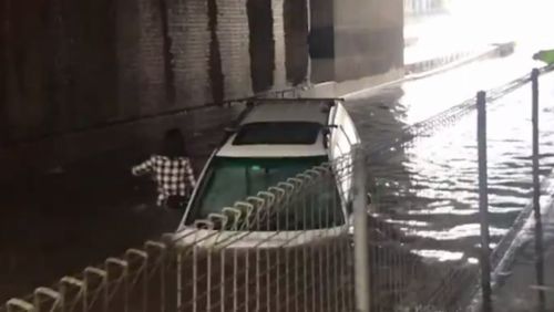 Mr Hernayes runs from his vehicle as it filled with water. (Luke Mortimer)