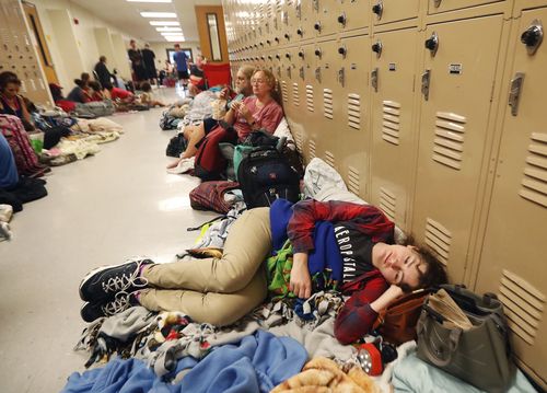 Emily Hindle lies on the floor at an evacuation shelter set up at Rutherford High School.