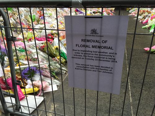 Flowers are being removed from the Sydney siege tribute at Martin Place ahead of forecast rain.