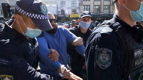 A man is held by police on Broadway, Sydney.