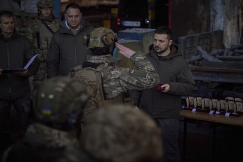 Le président ukrainien Volodymyr Zelenskyy, à droite, récompense un militaire sur le site des batailles les plus violentes avec les envahisseurs russes à Bakhmut, en Ukraine, le mardi 20 décembre 2022. 