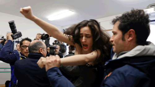The Italian election protester yelled and bore messages criticising Silvia Berlusconi. (AAP)