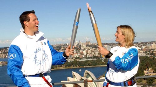 Zali Steggall during the 2000 Olympics torch relay, passing the flame over to Kieran Perkins on the Sydney Harbour Bridge.