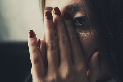 Woman crying with hands on her face