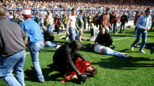 Stewards and supporters tend and care for wounded supporters on the field at Hillsborough Stadium, in Sheffield, England, April 15, 1989. (AP Photo, File)