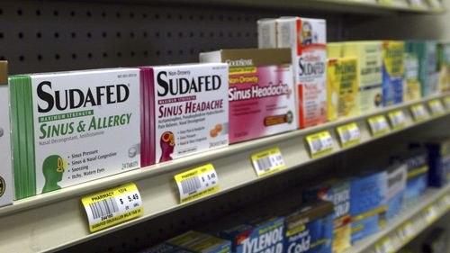 Sudafed and other common nasal decongestants containing pseudoephedrine are on display behind the counter at a pharmacy.