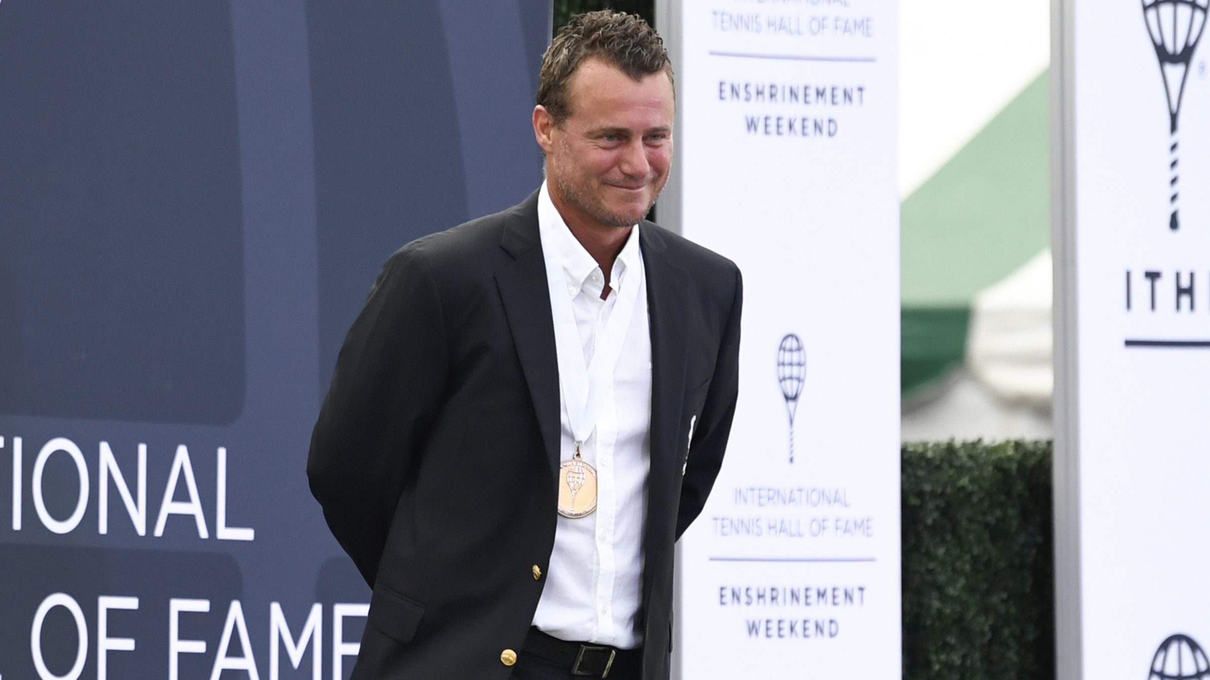 Lleyton Hewitt stands on stage during the International Tennis Hall of Fame 2022 Induction Ceremony.