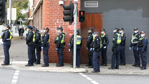 Protective service police officers walk towards the Flemington Public housing flats 
