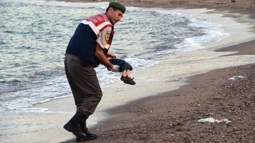 Aylan Kurdi being carried from the sea.