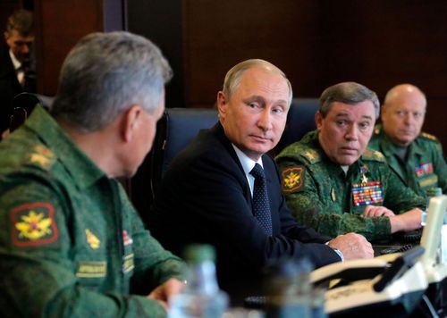 Russian President Vladimir Putin confers with his top military advisors.